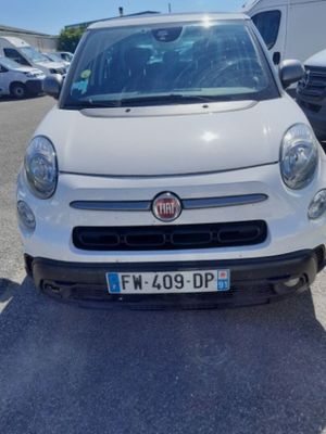 the small white car is parked in the parking lot