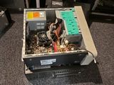 a computer sitting on top of a desk with a lot of wires on it