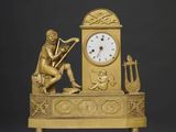 une horloge en or représentant un homme jouant d'un instrument de musique