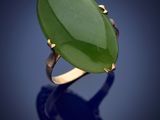 une bague ovale en jade vert sur fond bleu