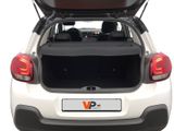 the back end of a white car with its trunk open