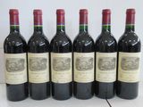 six bouteilles de vin sont alignées sur une table