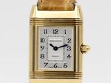 a close up of a gold watch with a white face