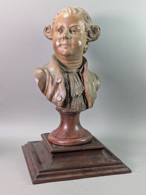 bronze bust of a man with a scarf on a wooden base