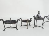 three pieces of black iron with a bowl and a saucer