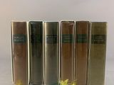 four books are lined up in a row on a white surface