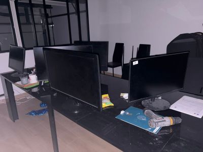 trois écrans d'ordinateur posés sur un bureau dans une pièce