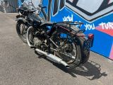 une moto noire garée devant un mur recouvert de graffitis