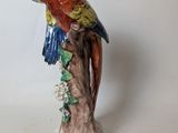 a figurine of a parrot perched on a tree branch
