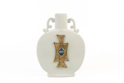 un vase blanc orné d'une croix dorée