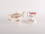 pair of small porcelain teapots with floral designs on them