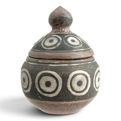 a black and white vase with a lid on a white surface