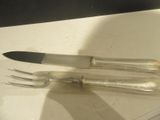 deux fourchettes et un couteau posés sur une table
