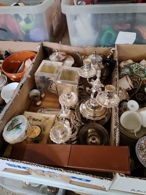 une boîte remplie d'objets hétéroclites posée sur le sol