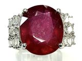 un gros plan d'une bague sertie d'un rubis et de diamants sur une surface blanche