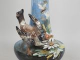 a blue vase with a bird on top of it