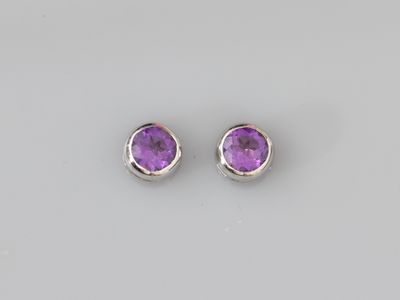 une paire de boucles d'oreilles en améthorate sur fond blanc