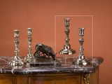 trois bougies posées sur une table en marbre sur laquelle trône une figurine d'oiseau