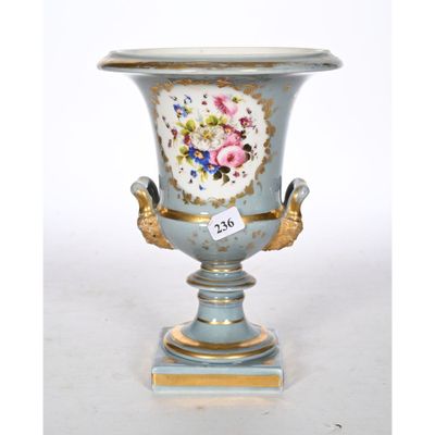 a blue vase with flowers on it sitting on a stand
