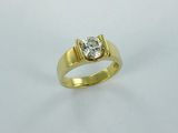 a yellow gold ring with a diamond on top of it