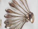 a lot of silver spoons and forks on a table