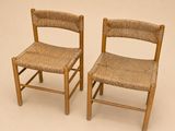 une paire de chaises en bois avec des assises tressées, sur fond blanc