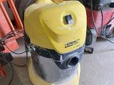 un aspirateur jaune et noir posé à côté d'une chaise rouge