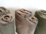 three old gas cans sitting next to each other on a table