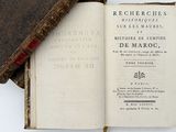 an old book sitting on top of a white table next to a book
