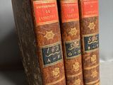three old books sitting on top of each other on a table