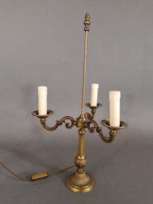 un chandelier ancien en laiton à cinq bougies, posé sur un socle