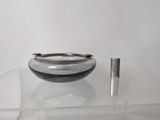 a silver object on a clear table with a silver object in the background