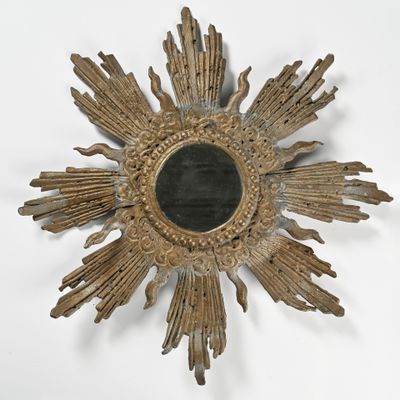 un motif « sunburst » doré avec un miroir noir au centre