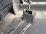 a fork lifter that is sitting in the middle of the street