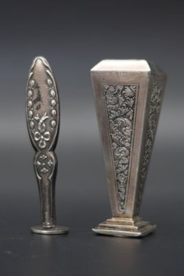 pair of silver spoons on a black surface with a gray background