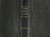 an old book with a black cover sitting on top of a table