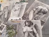 a pile of drawings on the ground next to a red wall