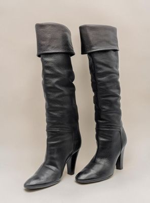 une paire de bottes en cuir noir sur fond blanc