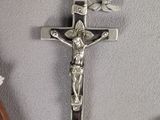 a crucifix on a wall with flowers around it