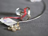a silver ring with a red string attached to it