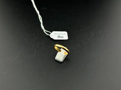 a close up of a white and gold ring on a string