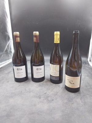 quatre bouteilles de vin sont alignées sur une table