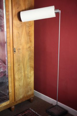 un rouleau de papier toilette posé par terre à côté d'une armoire