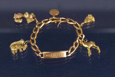 une image représentant un bracelet en or orné d'éléphants et d'une pièce de monnaie