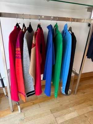 a lot of clothes hanging on a rack in a room