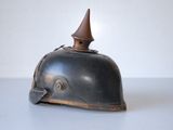 an old black helmet with a wooden top sitting on a table