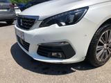 the front end of a white car parked in a parking lot