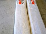 two rolls of white fabric on the floor in a room
