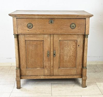 un vieux meuble en bois avec deux portes et un tiroir en dessous