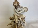 statue représentant une femme tenant un bébé et un enfant dans ses bras